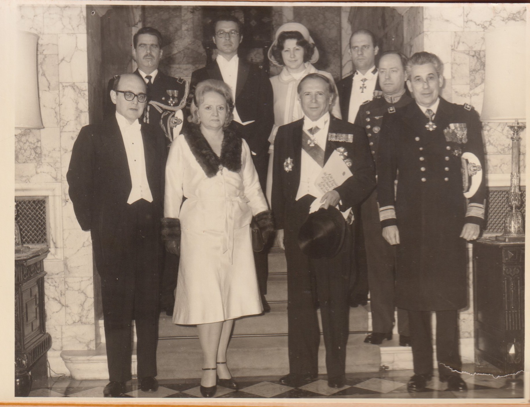A delegação brasileira posa para foto em evento no Palácio de Buckingham, em Londres, por ocasião da visita oficial do então presidente Ernesto Geisel a Inglaterra. Vitoria Cleaver, à época secretária da embaixada, está na fila mais elevada (é a terceira da esquerda para a direita). Logo abaixo dela, na fila inferior, está o embaixador brasileiro em Londres, Roberto Campos.